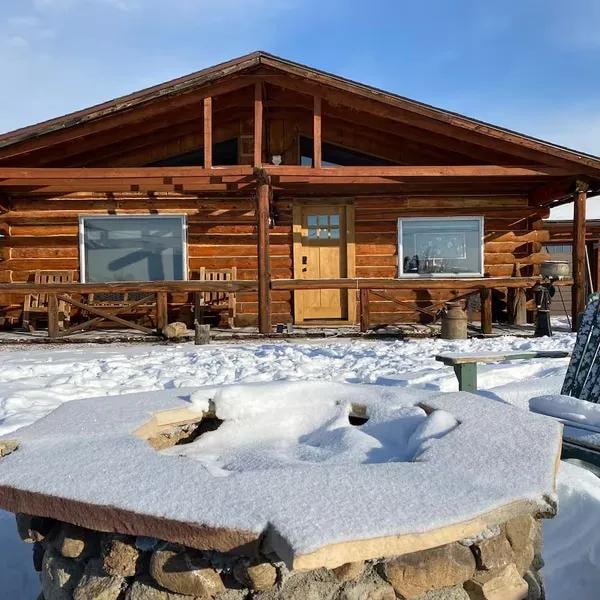 Legacy Cabin log home surrounded by snow in Twin Lakes